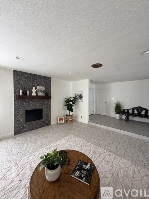 A room with a fireplace and a window showing a street view.