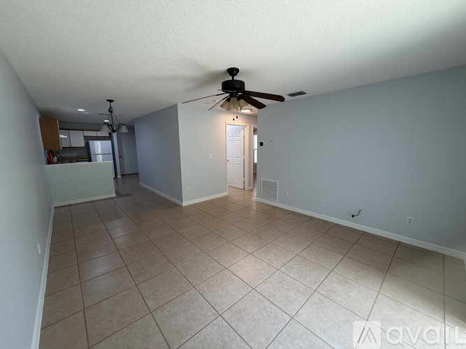A spacious room with a ceiling fan and tile flooring.