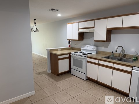 A kitchen with white appliances and brown cabinets.