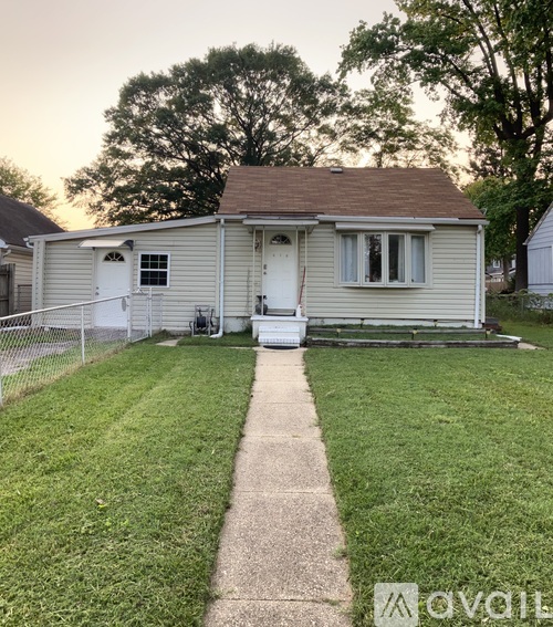 A small house with a white door and a white garage door.