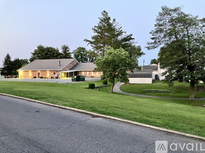 A house with a well-maintained lawn and trees in the background.