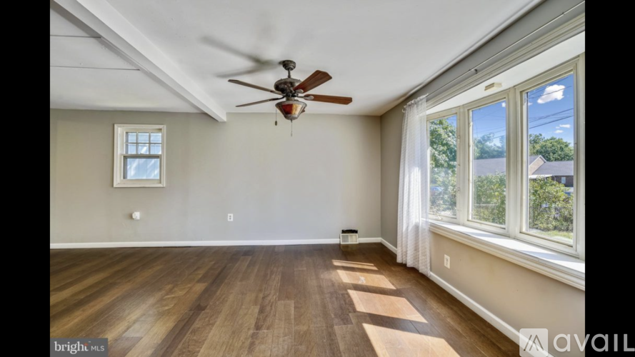 A room with a ceiling fan and a window.