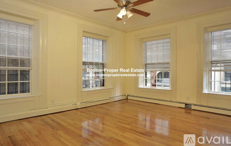 A room with wooden floors and a ceiling fan.
