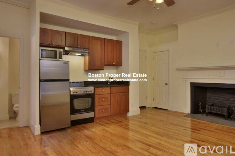 A kitchen with wooden cabinets and a stainless steel refrigerator.