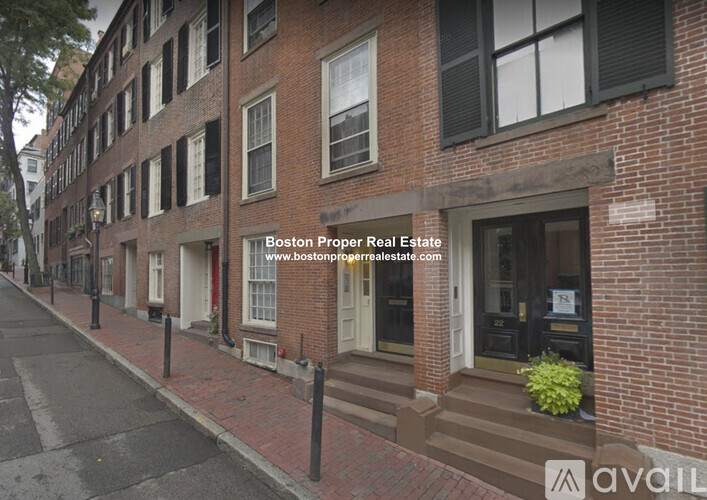 A street view of a building with the text "Boston Proper Real Estate" and a website address.