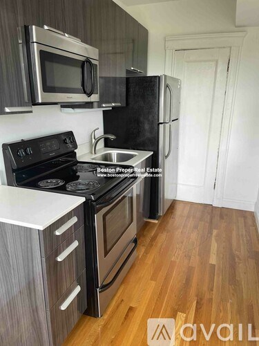 A kitchen with a black stove top oven and a black refrigerator.