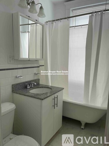 A bathroom with a toilet, sink, and shower.