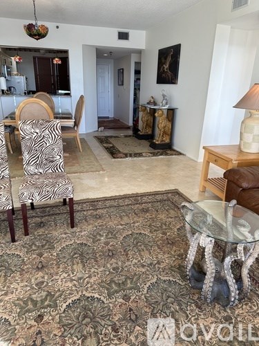A living room with a zebra print chair and a glass coffee table.
