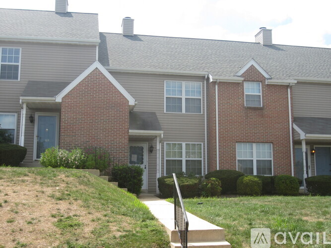 A brick house with a grey roof and a white door.