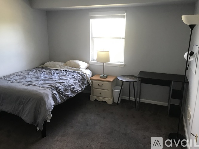 A bedroom with a bed, desk, and chair.