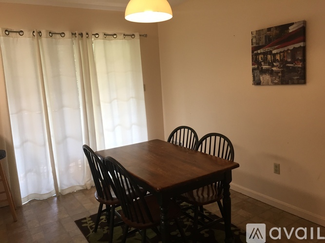 A dining room with a wooden table and chairs.