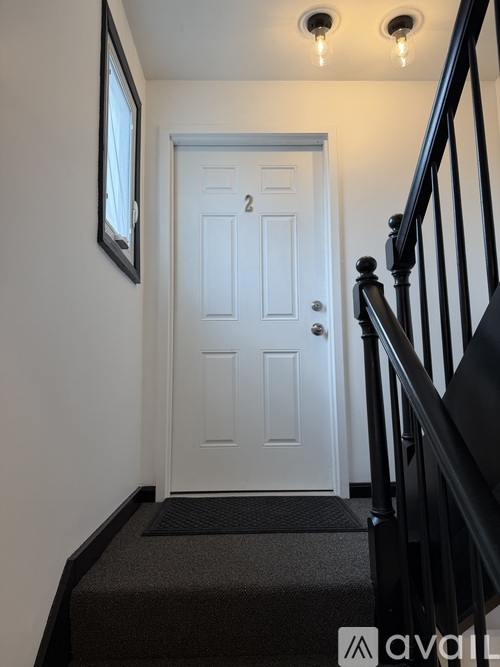 A white door is at the end of a staircase.