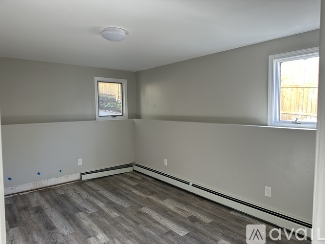 A room with a window and a wooden floor is available for rent.