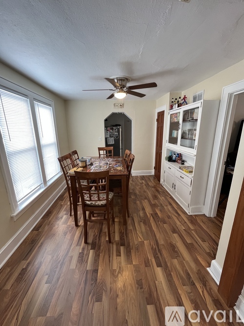 A dining room with a wooden table and chairs.