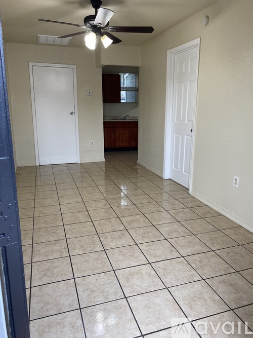 A room with a fan and tile flooring.