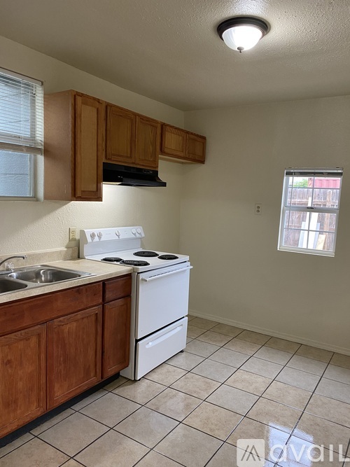 A kitchen with white appliances and wooden cabinets.