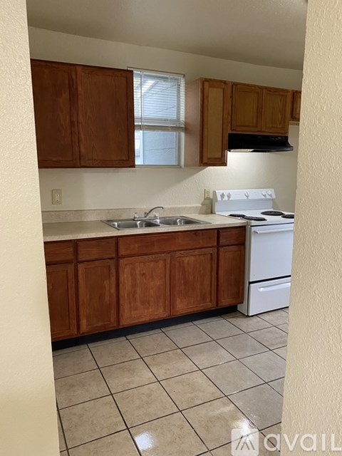 A kitchen with wooden cabinets and a white stove.