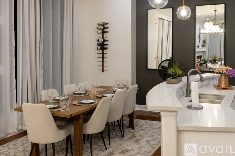 A modern dining room with a wooden table and white chairs.