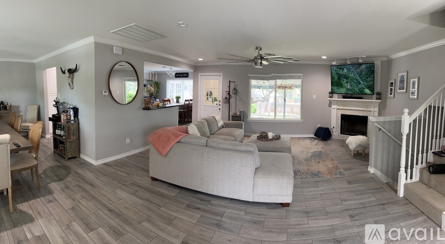 A living room with a grey couch and a fireplace.