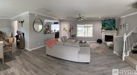 A living room with a grey couch and a fireplace.