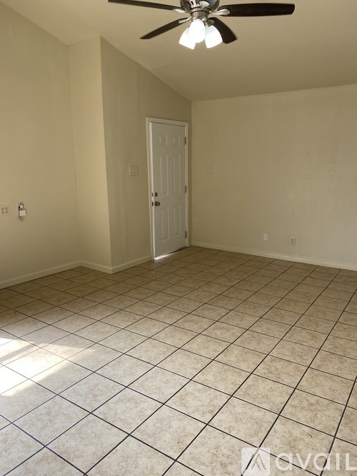 A room with a ceiling fan and tile flooring.