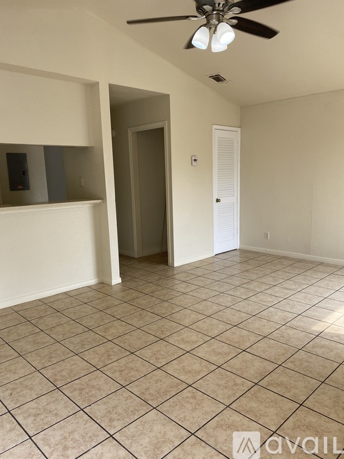 A room with a ceiling fan and tiled flooring.
