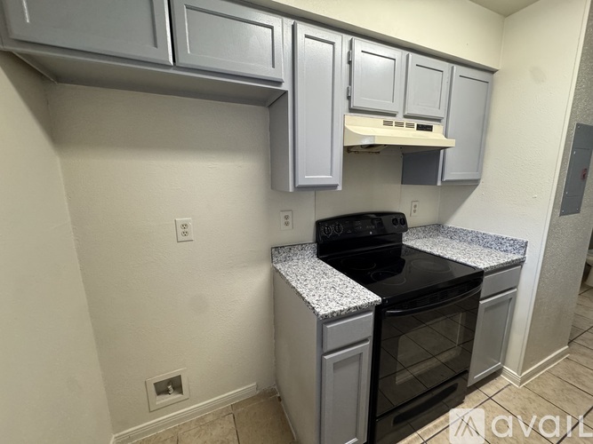 A kitchen with a black stove top oven and white cabinets.