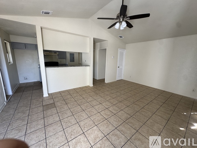 A room with a ceiling fan and tiled flooring.