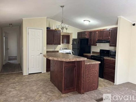 A kitchen with brown cabinets and a granite countertop.