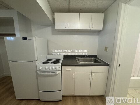 A kitchen with white appliances and cabinets is available for rent.