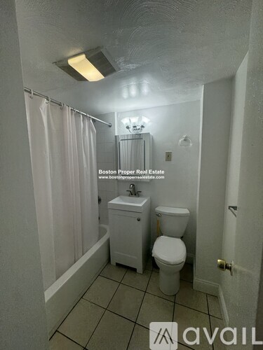 A small bathroom with a toilet, sink and shower.