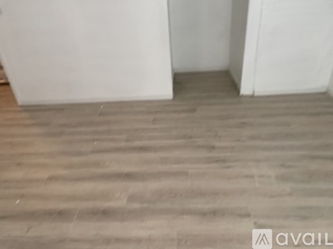 A room with wooden flooring and white walls.
