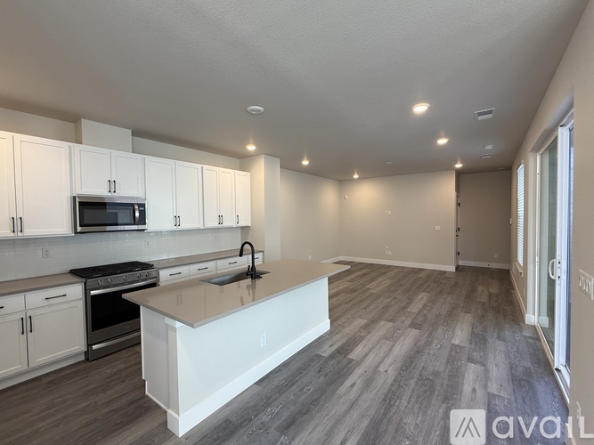 A kitchen with white cabinets and a white island with a sink.