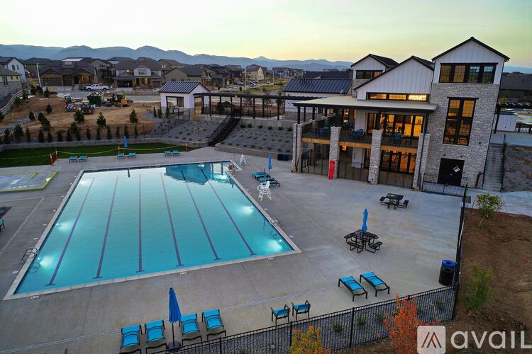 A large swimming pool surrounded by a fence and a building in the background.