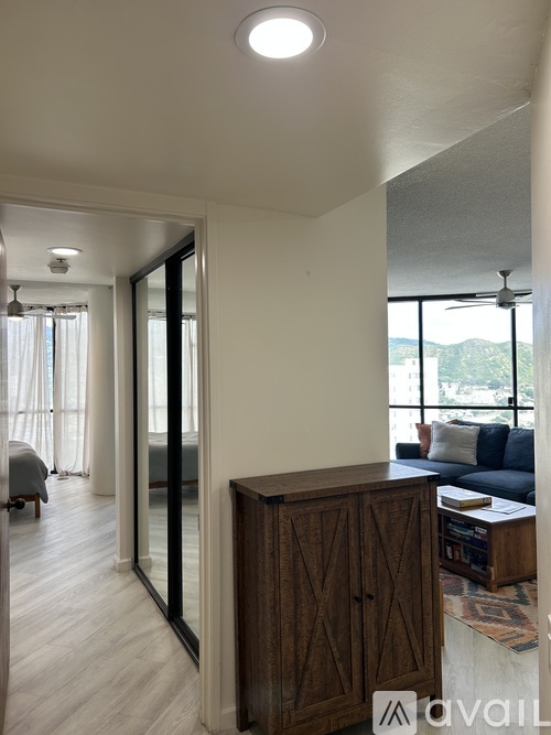 A living room with a couch, a wooden cabinet, and a ceiling fan.