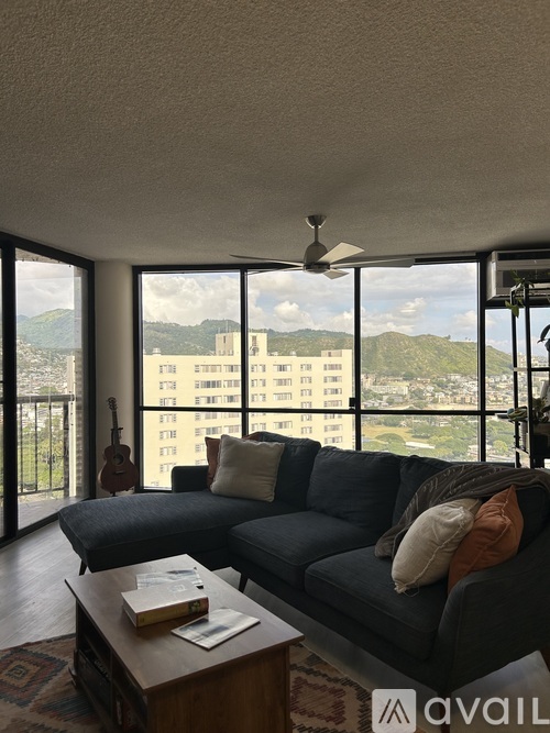 A living room with a large couch and a view of the city.