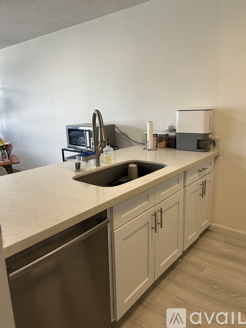 A kitchen with a sink, dishwasher, and microwave.