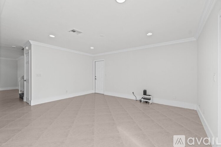 A spacious room with a tiled floor and a small stool in the corner.
