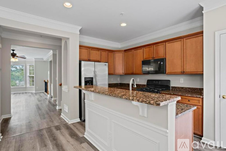 A kitchen with wooden cabinets and a granite countertop.