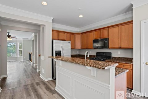 A kitchen with wooden cabinets and a granite countertop.