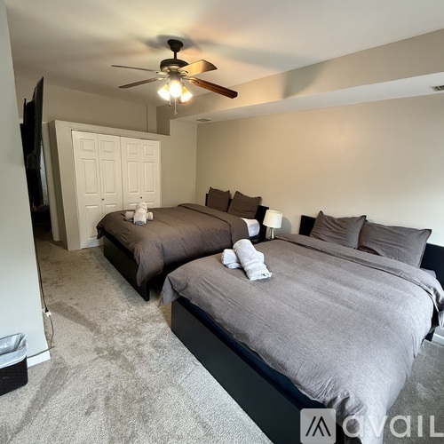 A bedroom with two beds and a ceiling fan.