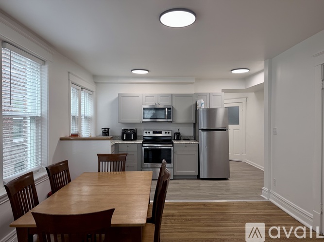A kitchen with a table and chairs in front of it.