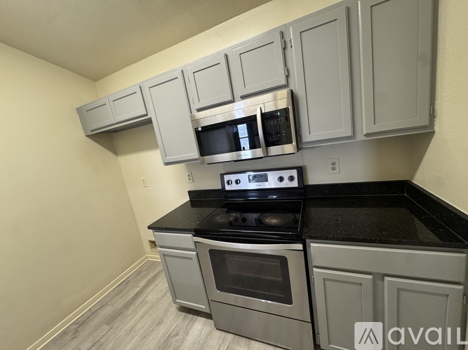 A kitchen with a stove, oven, and microwave.