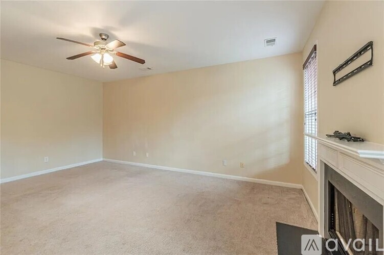 A living room with a carpeted floor and a fireplace.