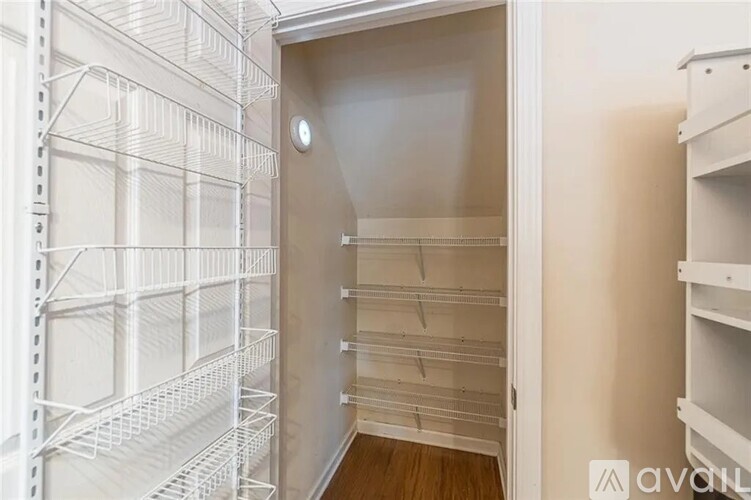 A white walk-in closet with shelves and a door.
