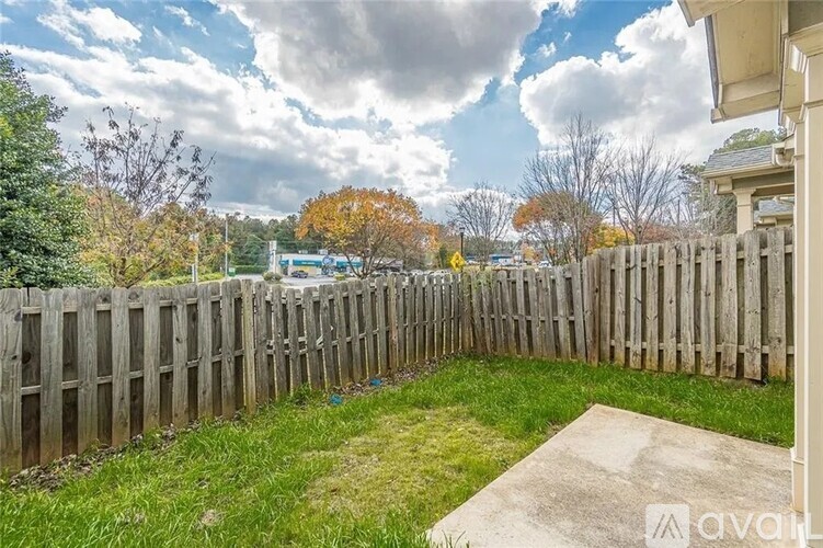 A wooden fence surrounds a grassy yard.