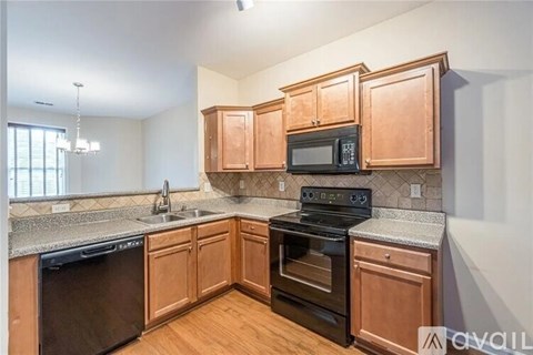 A kitchen with wooden cabinets and black appliances.