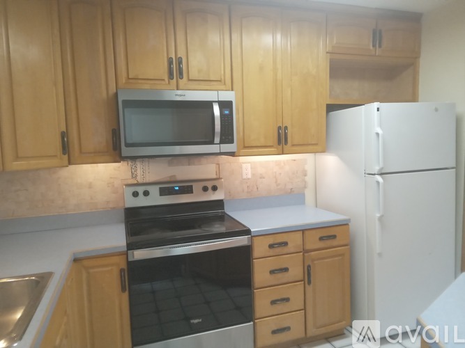 A kitchen with wooden cabinets and a white refrigerator.