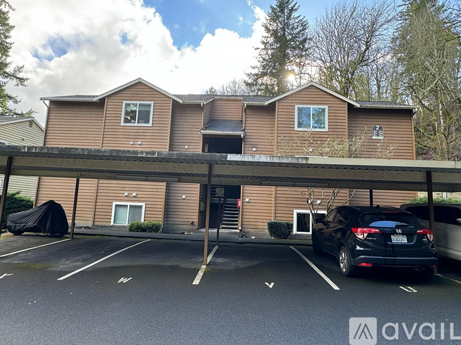 A parking lot with a building in the background and a car parked in the foreground.