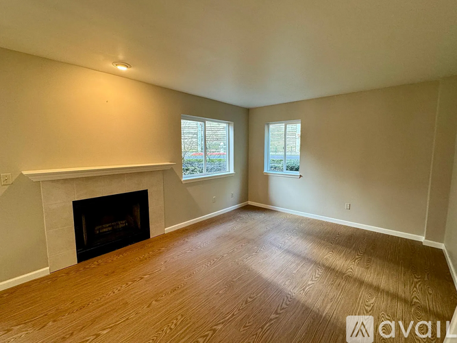 A room with a fireplace and two windows.